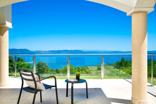 a balcony with a table and chairs and a view of the water at Luxury Panorama Vila with amazing Seaview in Gondolici 7 km from Rabac in Labin