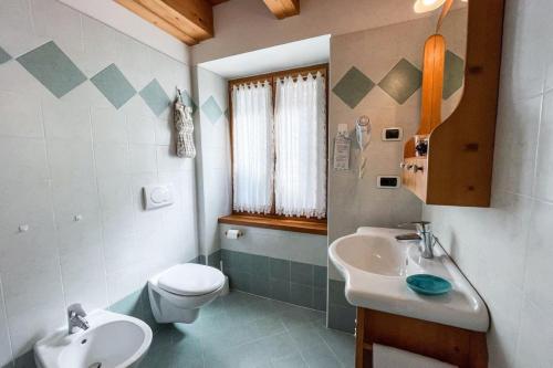a bathroom with a sink and a toilet and a sink at Room & Breakfast Cà mea Dina in Ledro