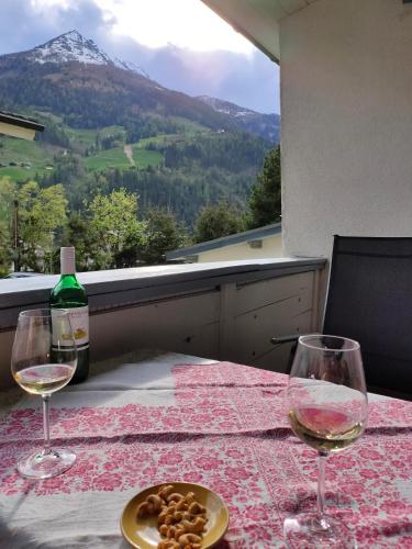 a table with two glasses and a bottle of wine at Ferienhaus Ahornli im Mölltal in Großkirchheim