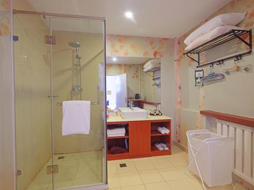 a bathroom with a shower and a sink at Xindao Xitai Xiaozhu Hotel in Huangkan