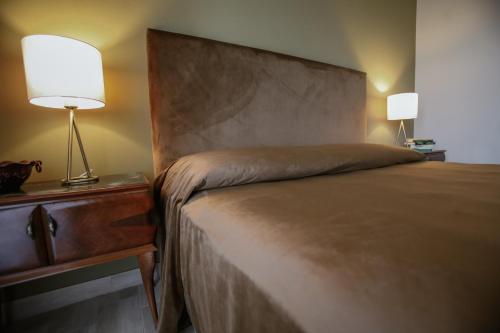 a bedroom with a bed and a lamp on a nightstand at CA'du LIN - Jacuzzi e Piscina in Cisterna dʼAsti