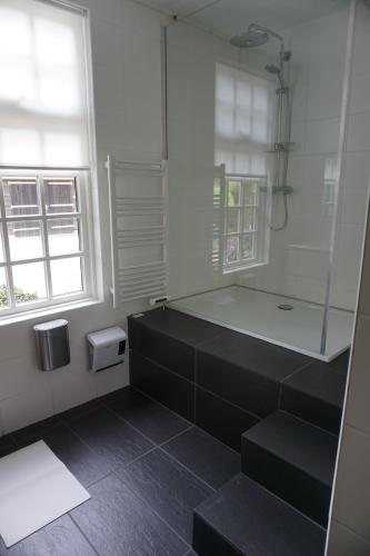 a bathroom with a shower and a bath tub at Charmantbuiten in Zandhuizen