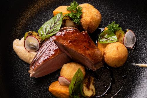a plate of food with meat and vegetables on it at Lubhotel in Lublin