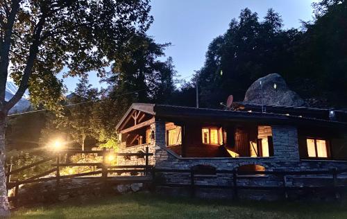 a log cabin in the woods at night at CHALET A CERESOLE REALE nel Parco Gran Paradiso in Ceresole Reale