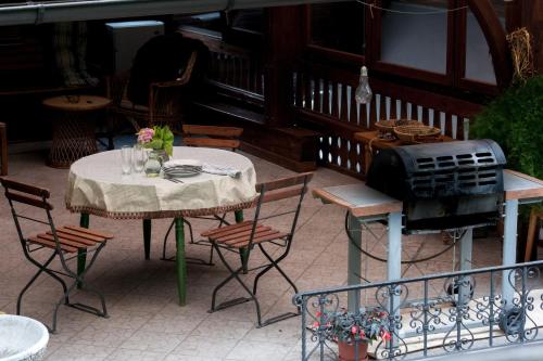 a table and chairs on a patio with a grill at Apartma Ajda in Železniki
