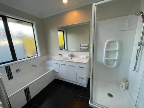 a bathroom with a tub and a sink and a shower at Your Happy place-Quiet area & Spa pool in Rotorua