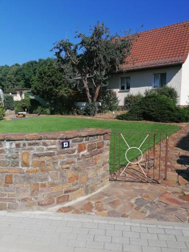 a brick wall with a gate in front of a house at Ferienhaus Rosmarie am Elbradweg in Grödel