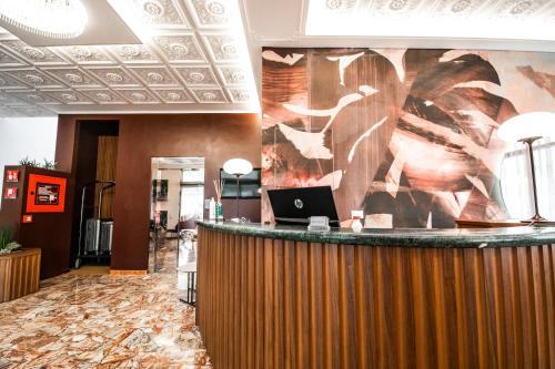 a lobby with a bar with a laptop on the wall at Hotel Souvenir in Lido di Jesolo