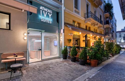 a street with a table and potted plants in front of a building at Athens Ivy Suites in Athens