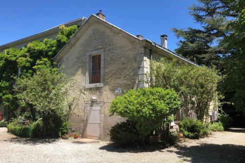 una vecchia casa in pietra con una porta e alberi di Independent cottage with heated pool a Lempaut