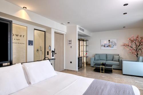 a bedroom with a white bed and a couch at Athens Ivy Suites in Athens