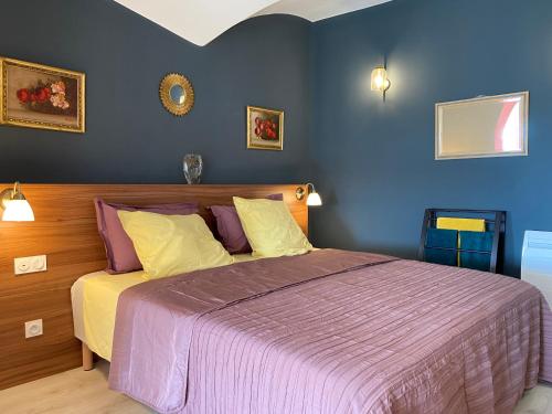 una camera da letto con un letto con un piumone viola di Grand Appartement Centre historique Grasse a Grasse