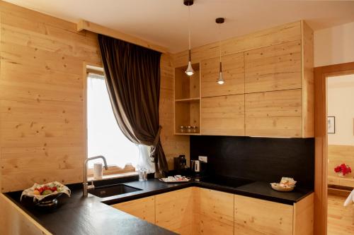 a kitchen with wooden walls and a black counter top at Chalet del Capriolo in Vodo Cadore
