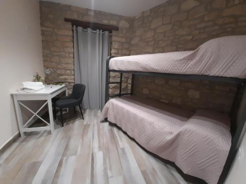 ein Schlafzimmer mit einem Etagenbett und einem Schreibtisch mit einem Schreibtisch in der Unterkunft Pati de Cal Espardenyer in Vallbona de les Monges