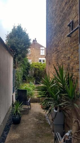 a courtyard with plants in front of a brick building at Homey, warm & welcoming room. in London