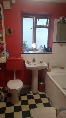 a bathroom with a toilet and a sink and a tub at Homey, warm & welcoming room. in London