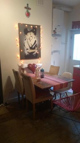 倫敦的住宿－Homey, warm & welcoming room.，餐桌、椅子和墙上的绘画