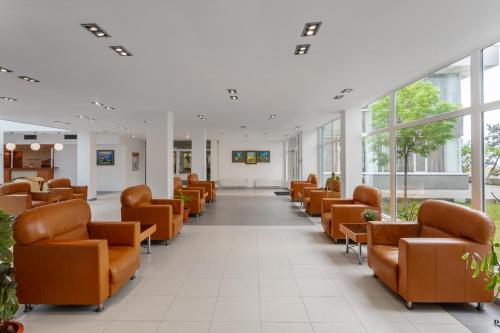 a waiting room with orange chairs in a hospital at Hotel Sirena Saturn All Inclusive in Saturn