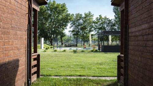 an open door of a brick building with a park in the background at Camping Divoká Voda in Bratislava