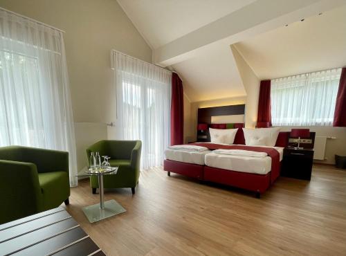 a bedroom with a bed and two chairs at Thalhauser Mühle Hotel-Restaurant in Thalhausen