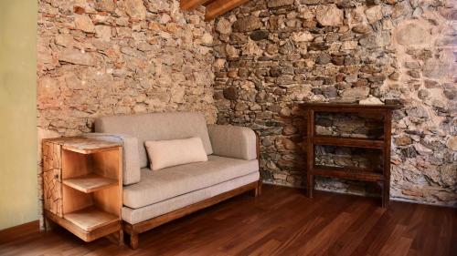 a living room with a chair and a stone wall at Il Ronchetto in Cunardo