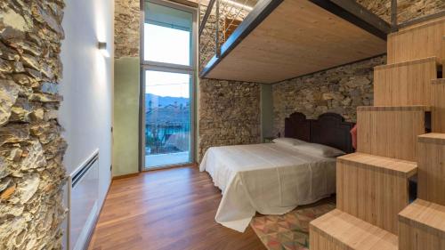 a bedroom with a bed and a stone wall at Il Ronchetto in Cunardo
