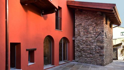 a red building with a stone wall at Il Ronchetto in Cunardo