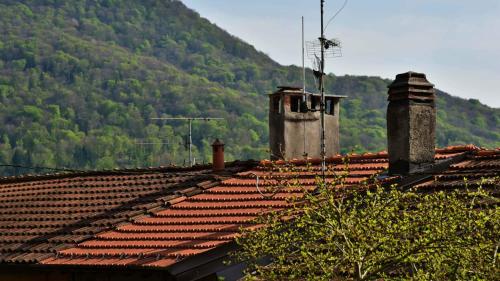 a view of roofs of houses with mountains in the background at Il Ronchetto in Cunardo