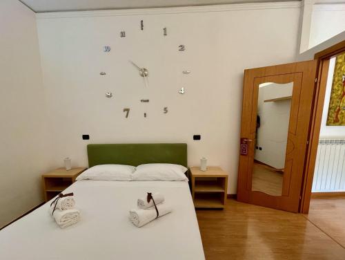 - une chambre avec un lit et une horloge murale dans l'établissement Maria Carolina Casavacanze, à Caserte