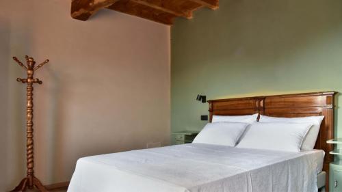 a bedroom with a large white bed with a wooden headboard at Il Ronchetto in Cunardo