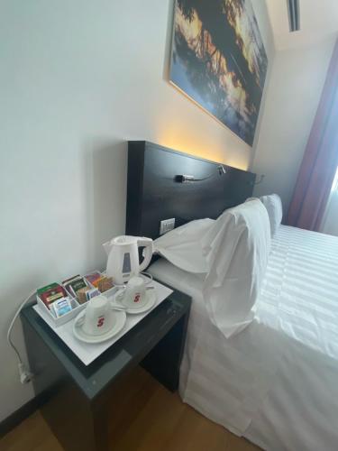 a hotel room with a bed and a table with plates and cups at Card International Hotel in Rimini