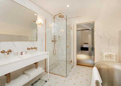 a white bathroom with a sink and a shower at Schloss Fellin Boutique Hotel and Spa in Viljandi