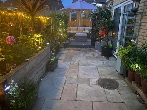 a backyard patio with a seating area with plants and lights at Secret Gem 1 Bed Garden Flat Private Luxury Hot Tub in Bournemouth