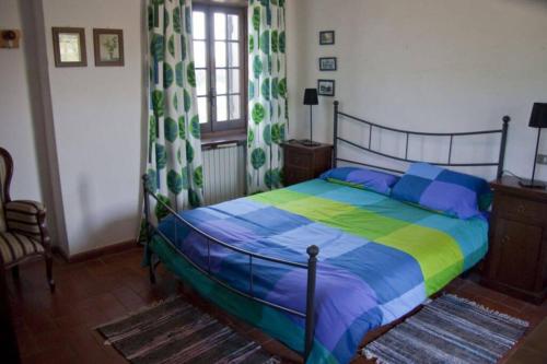 ein Schlafzimmer mit einem Bett mit einer bunten Bettdecke in der Unterkunft La Prediletta Country House in Rapino