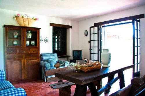 uma sala de estar com uma mesa de madeira e cadeiras azuis em La Prediletta Country House em Rapino