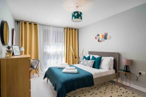 a bedroom with a bed with a blue blanket and a window at Kew Gardens retreat in Kew Bridge