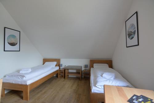 a room with two beds and a table at G&G Boardinghouse in Aalen