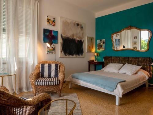 ein Schlafzimmer mit einem Bett, einem Stuhl und einem Spiegel in der Unterkunft Cinque terre affittacamere Atelier ouvert! in La Spezia