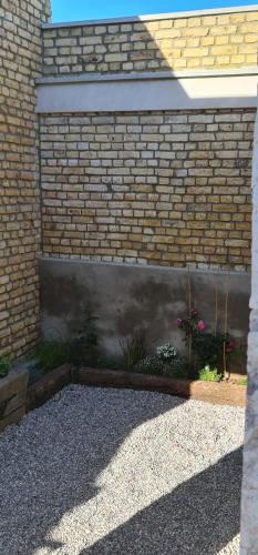 a brick wall with a garden in a yard at Le Pigeonnier Spa du Panty Gîte rural de charme in Saint-Tricat