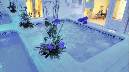 a pool of water with purple flowers in it at Hotel & Spa Entremares in La Manga del Mar Menor