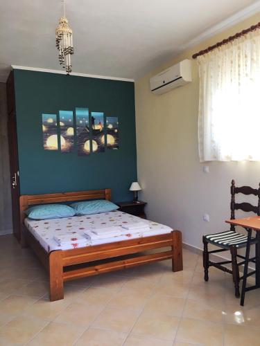 a bedroom with a bed and a green wall at Vrachos Sunrise Apartment in Vrachos