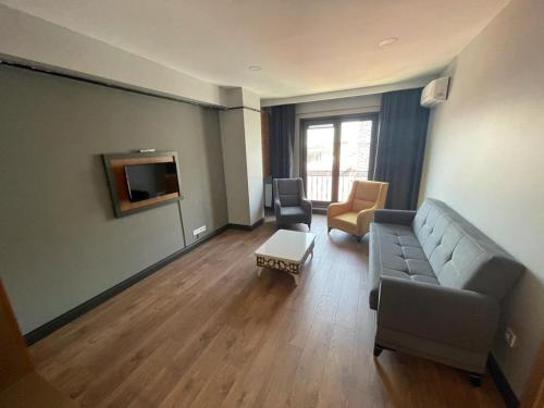 sala de estar con sofá y 2 sillas en Almina Apartments&Suites en Estambul