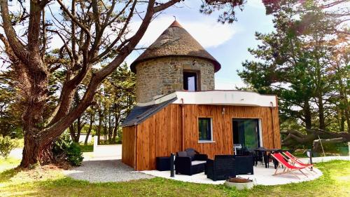 una pequeña cabaña con chimenea encima en MOULIN DE KERNOT en Cléden-Cap-Sizun