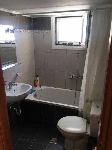 a bathroom with a tub and a toilet and a sink at Vrachos Sunrise Apartment in Vrachos