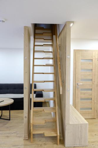 a spiral staircase in a room with a table at Apartmány Valča in Valča
