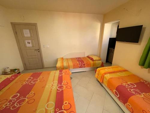 a room with two beds and a flat screen tv at Apartments Pericic in Sutomore