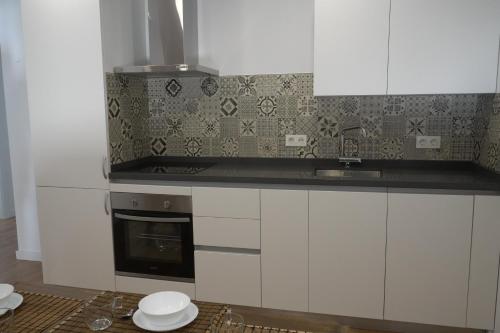 een keuken met witte kasten en een fornuis met oven bij Almona de Triana - Kainga Homes in Sevilla