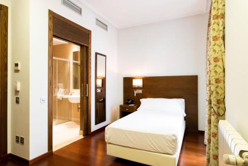 a hotel room with a bed and a bathroom at Soho Boutique Oviedo in Oviedo