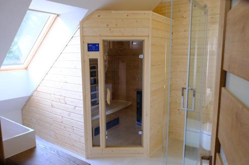 ein hölzernes Bad mit einer Dusche im Zimmer in der Unterkunft Apartmány Valča in Valča