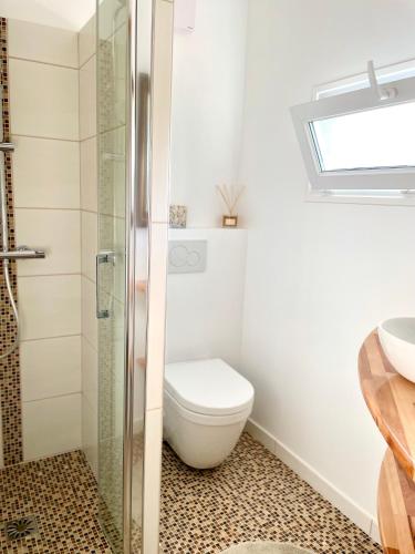 een badkamer met toilet en glazen douche bij Les Pinsons studio in La Ciotat